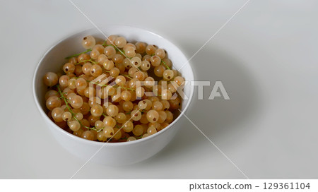 Fresh Yellow Currants in a White Bowl on White Background 129361104