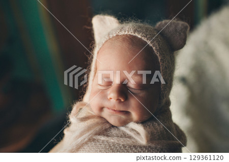 A newborn baby is wrapped in diapers with a wool cap in a basket. Swaddling, maternity hospital, family, ivf, life planning, parenting. A mother's love for her child. Baby food. High quality photo A newborn baby is wrapped in diapers with a wool cap in a basket. Swaddling, maternity hospital, family, ivf, life planning, parenting. A mother's love for her child. Baby food. High quality photo 129361120