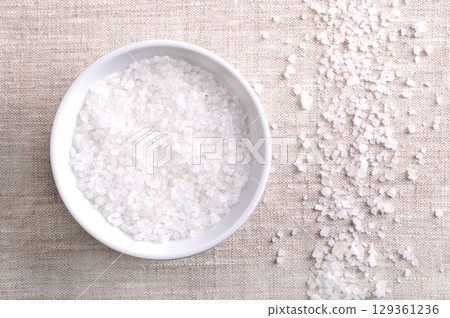 Dead Sea salt in a wooden bowl on linen. Coarse, crystalized salt, extracted from the Dead Sea. Rich in chloride, magnesium, sodium, calcium and potassium. Used as bath salt and in cosmetic products. Dead Sea salt in a wooden bowl on linen. Coarse, crystalized salt, extracted from the Dead Sea. Rich in chloride, magnesium, sodium, calcium and potassium. Used as bath salt and in cosmetic products. 129361236