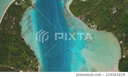 Aerial perspective showcases the stunning beauty of tropical islands, featuring lush green vegetation, crystal-clear turquoise waters, vibrant coral reefs, and a tranquil lagoon Aerial perspective showcases the stunning beauty of tropical islands, featuring lush green vegetation, crystal-clear turquoise waters, vibrant coral reefs, and a tranquil lagoon 129361819