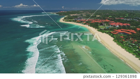 Stunning aerial view of Nusa Dua beach with breaking waves and luxury hotels along the coast meeting the turquoise water of the Indian Ocean in Bali, Indonesia Stunning aerial view of Nusa Dua beach with breaking waves and luxury hotels along the coast meeting the turquoise water of the Indian Ocean in Bali, Indonesia 129361898
