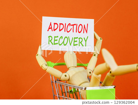 Addiction recovery symbol. Concept words Addiction recovery on beautiful white card. Psychologist model. Beautiful orange background. Psychology addiction recovery concept. Copy space. 129362004