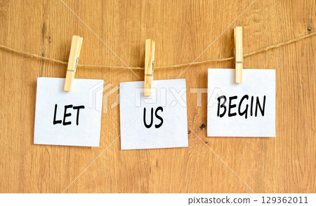 Let us begin symbol. Concept words Let us begin on beautiful white paper on clothespin. Beautiful wooden background. Business motivational let us begin concept. Copy space. Let us begin symbol. Concept words Let us begin on beautiful white paper on clothespin. Beautiful wooden background. Business motivational let us begin concept. Copy space. 129362011