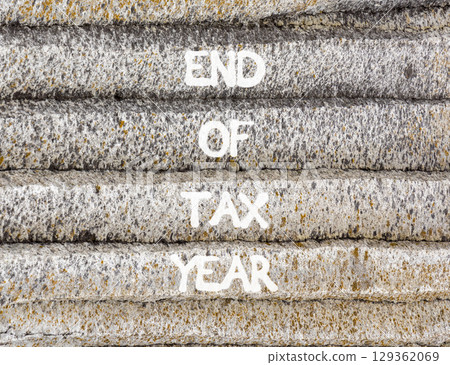 End of tax year symbol. Concept words phrase End of tax year on beautiful grey stone wall. Beautiful stone wall background. Business End of tax year concept. Copy space. End of tax year symbol. Concept words phrase End of tax year on beautiful grey stone wall. Beautiful stone wall background. Business End of tax year concept. Copy space. 129362069