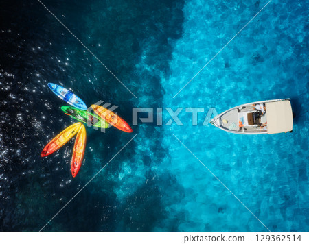 Aerial drone top view of colorful kayaks and motorboat on the sea 129362514