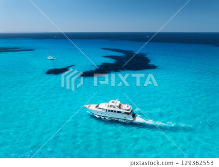 Aerial view of luxury yacht sailing in crystal clear blue sea Aerial view of luxury yacht sailing in crystal clear blue sea 129362553