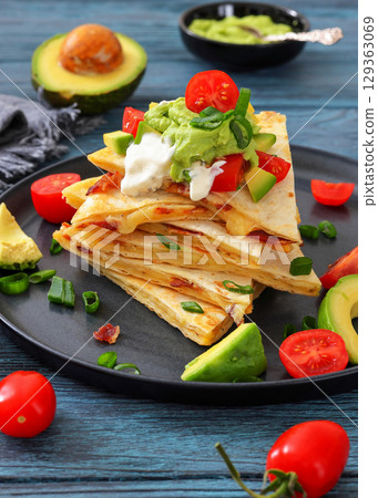 quesadilla with cheese, bacon, avocado on a plate 129363069