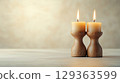 Two beige candles in rustic wooden holders create warm ambiance 129363599