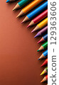 Vibrant colored pencils arranged on brown background 129363606