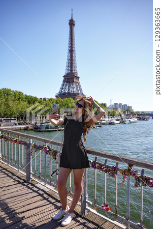 Woman posing on bridge with Eiffel Tower view in Paris 129363665