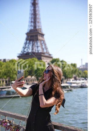 Woman taking selfie with Eiffel Tower in Paris Woman taking selfie with Eiffel Tower in Paris 129363697