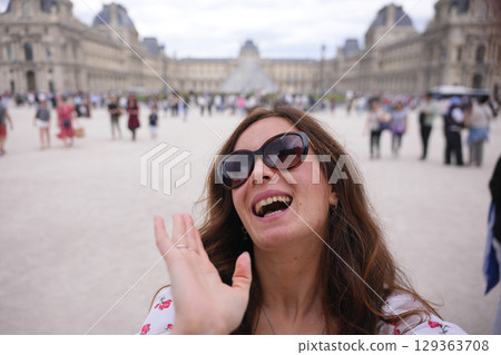 Woman waving and smiling at Louvre courtyard Paris Woman waving and smiling at Louvre courtyard Paris 129363708