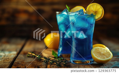 Blue Gin And Tonic Cocktail With Lemon Slices And Juniper Branch On An Antique Wooden Table 129363775
