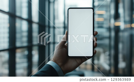 Businessman Demonstrating Data Transfer Between Mobile Smart Phone And Laptop Using Cloud Storage 129363989