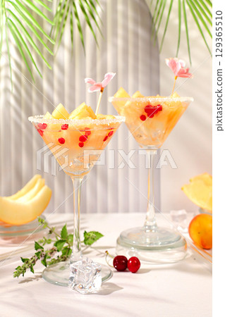 Melon alcoholic cocktail with mint. Martini and royal sangria with melon slices, ice, mint and currants. Summer party concept, advertising for a bar or cafe, detox diet Melon alcoholic cocktail with mint. Martini and royal sangria with melon slices, ice, mint and currants. Summer party concept, advertising for a bar or cafe, detox diet 129365510