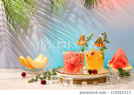 Mojito with melon, mint, watermelon, ice with tequila, vodka or soda water on elegant background, minimalist concept for bar, soft drink for weight loss, advertising banner for cafe Mojito with melon, mint, watermelon, ice with tequila, vodka or soda water on elegant background, minimalist concept for bar, soft drink for weight loss, advertising banner for cafe 129365513