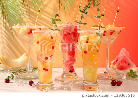 Summer party concept, bar or cafe advertisement. Melon and watermelon alcoholic cocktail with mint. Martini and royal sangria with melon slices, ice, mint and currants, detox diet 129365516