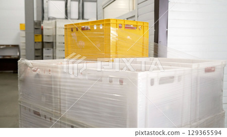 Plastic crates wrapped in stretch film in warehouse 129365594