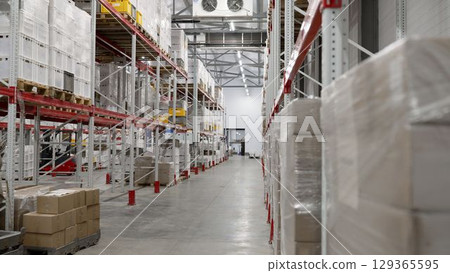 Goods stacked on industrial shelves in distribution warehouse 129365595