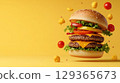 Double cheeseburger with lettuce, tomato, pepper and melted cheese floats on yellow background 129365673