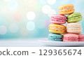 Pyramid of colorful macarons on white plate on pastel toned backdrop, copy space 129365674