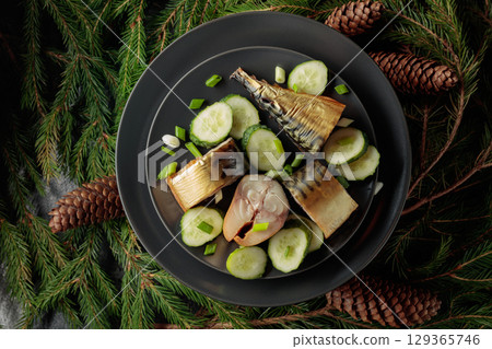Smoked mackerel with fresh cucumber and green onions on a black plate. Smoked mackerel with fresh cucumber and green onions on a black plate. 129365746