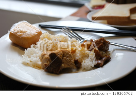 Tso's chicken with rice, onions and broccoli on the table. horizontal view from above  129365762
