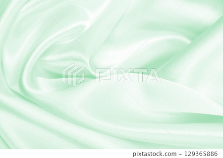 Smooth elegant green silk or satin luxury cloth texture as abstract background. Luxurious background design 129365886
