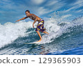 Male surfer on a blue wave 129365903