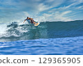 Male surfer on a blue wave 129365905