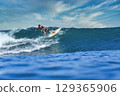 Male surfer on a blue wave 129365906