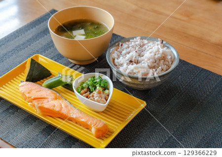 A healthy Japanese breakfast of grilled salmon, natto, and mixed grain rice 129366229