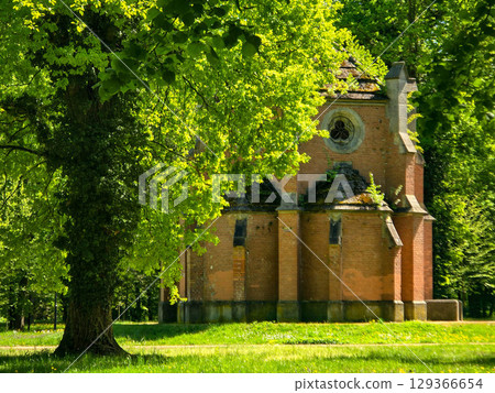 Historic church in a picturesque park under a clear blue sky 129366654