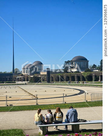 People Relaxing Near Historic Architecture in Urban Park 129366675