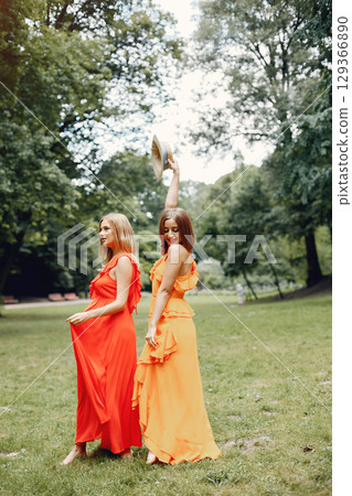 Beautiful girl in a red dress. Women in a summer park. 129366890