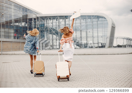 Girls at the airport. Friends with suitcasess 129366899