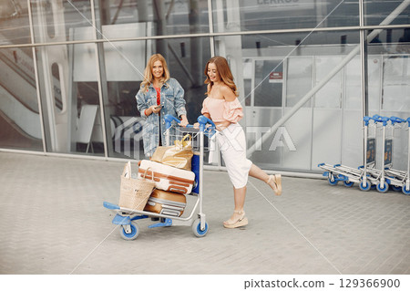 Girls at the airport. Friends with suitcasess Girls at the airport. Friends with suitcasess 129366900