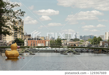 the waterways of the former West India Docks on Canary Wharf in London's Docklands. It features a large yellow duck floating on the water. the waterways of the former West India Docks on Canary Wharf in London's Docklands. It features a large yellow duck floating on the water. 129367889
