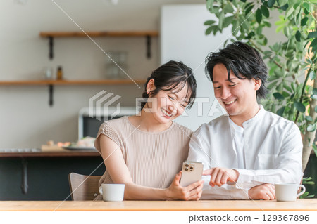 Couples, men and women looking at smartphones and apps at home Couples, men and women looking at smartphones and apps at home 129367896