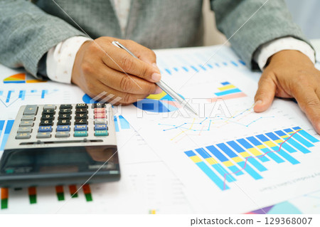 Asian business woman working with financial graph. 129368007