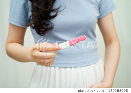 Asian holding pregnancy test for female of ovulation day, fetus, maternity, childbirth, birth control. 129368008