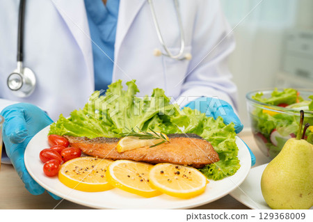 Asian Nutritionist holding healthy food for patient in hospital, nutrition and vitamin. Asian Nutritionist holding healthy food for patient in hospital, nutrition and vitamin. 129368009