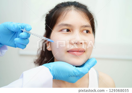 Asian woman receiving lip contouring procedure augmentation performed on face. 129368035