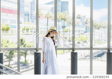 一位戴著草帽的年輕女子正在觀光 一位戴著草帽的年輕女子正在觀光 129368145