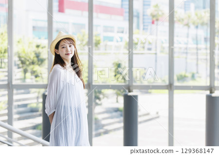 一位戴著草帽的年輕女子正在觀光 一位戴著草帽的年輕女子正在觀光 129368147