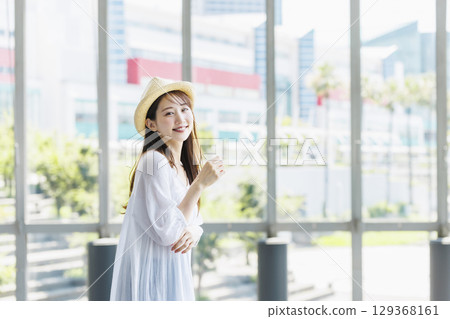 A young woman wearing a straw hat enjoying sightseeing 129368161