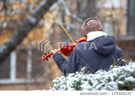 Street musician playing the violin. Musical creativity. Bowed stringed musical instrument 129368187