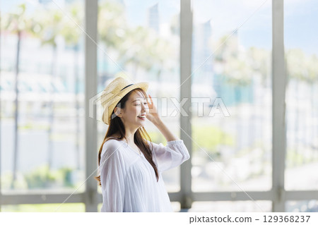 A young woman wearing a straw hat enjoying sightseeing 129368237