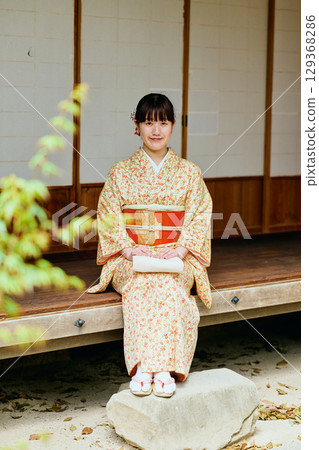 一位身著和服的女子靜靜地站在陽台上 129368286