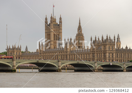 Palace of Westminster (the Houses of Parliament) with the Westminster Bridge spanning the river thames in the foreground. 129368412